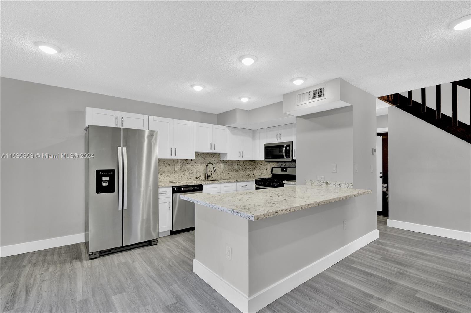 a kitchen with stainless steel appliances a refrigerator sink and microwave