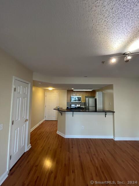 a kitchen with stainless steel appliances wooden floors and view living room