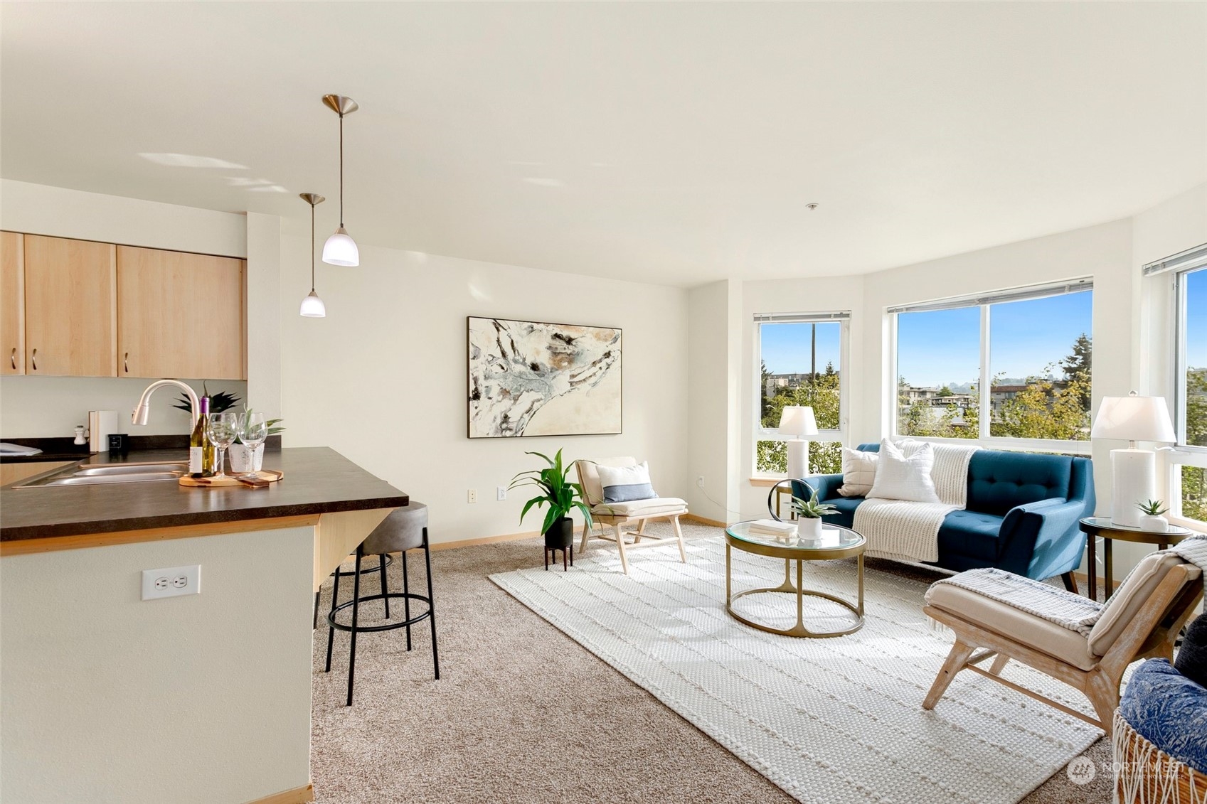 a living room with furniture a table and kitchen view