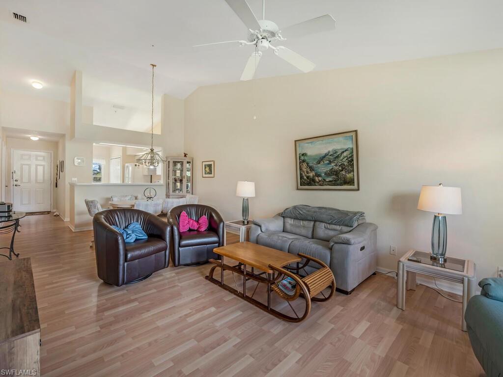 Living room featuring ceiling fan, hardwood / wood-style floors, and lofted ceiling