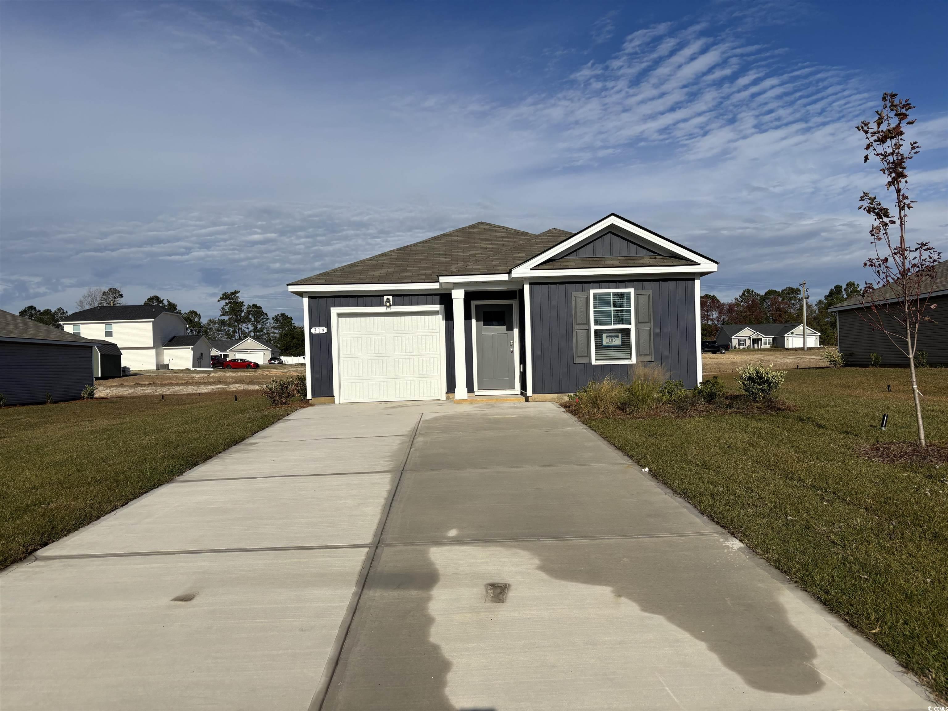 View of front of home with a garage and a front la