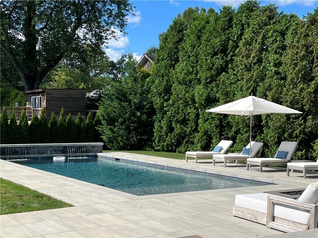 View of pool with waterfall feature, patio and lounge area