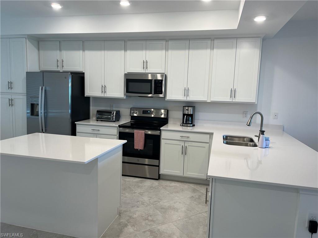 a kitchen with white cabinets and stainless steel appliances