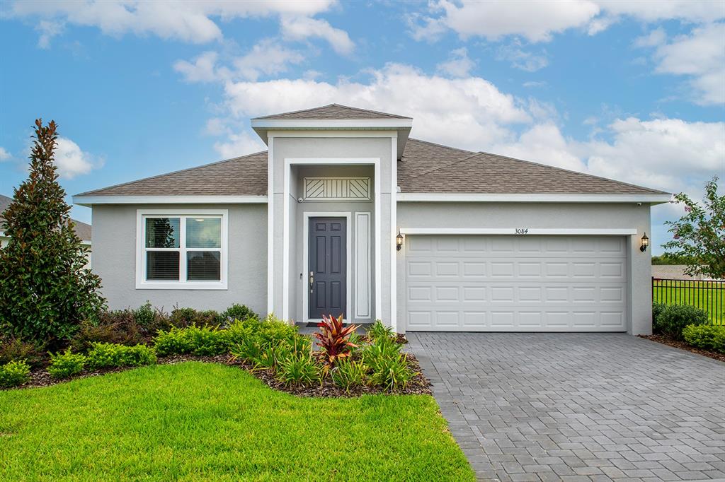 a front view of a house with a garden and garage