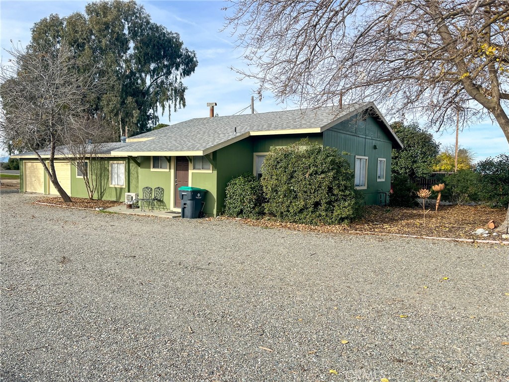 a view of a house with a tree in front of it