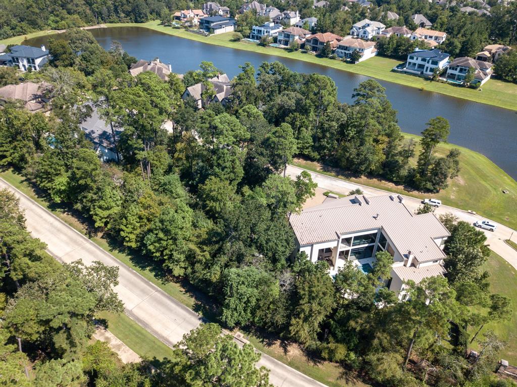 an aerial view of a house with a yard and lake view