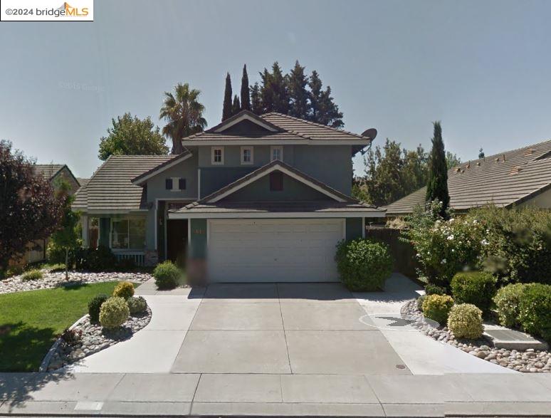 a front view of a house with a yard and potted plants