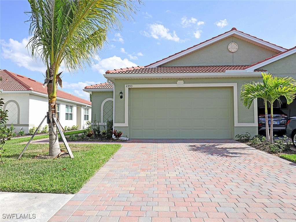 a front view of a house with a yard and palm trees