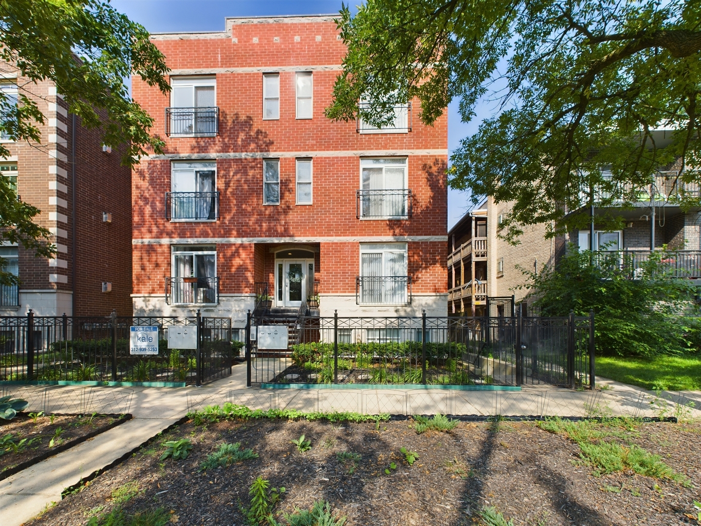 a front view of a residential apartment building with a yard