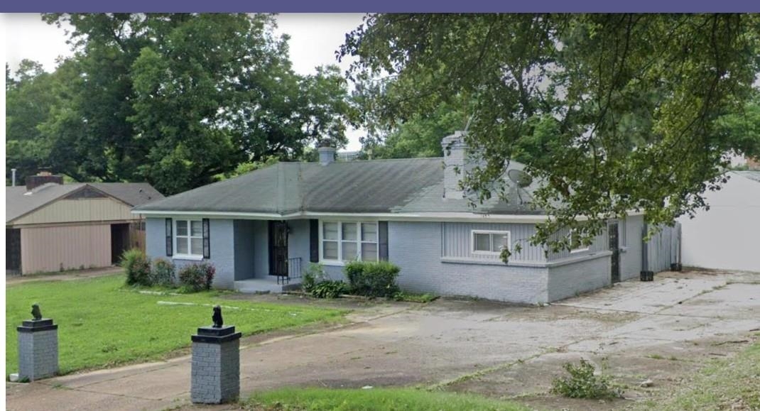 a front view of a house with a garden and yard