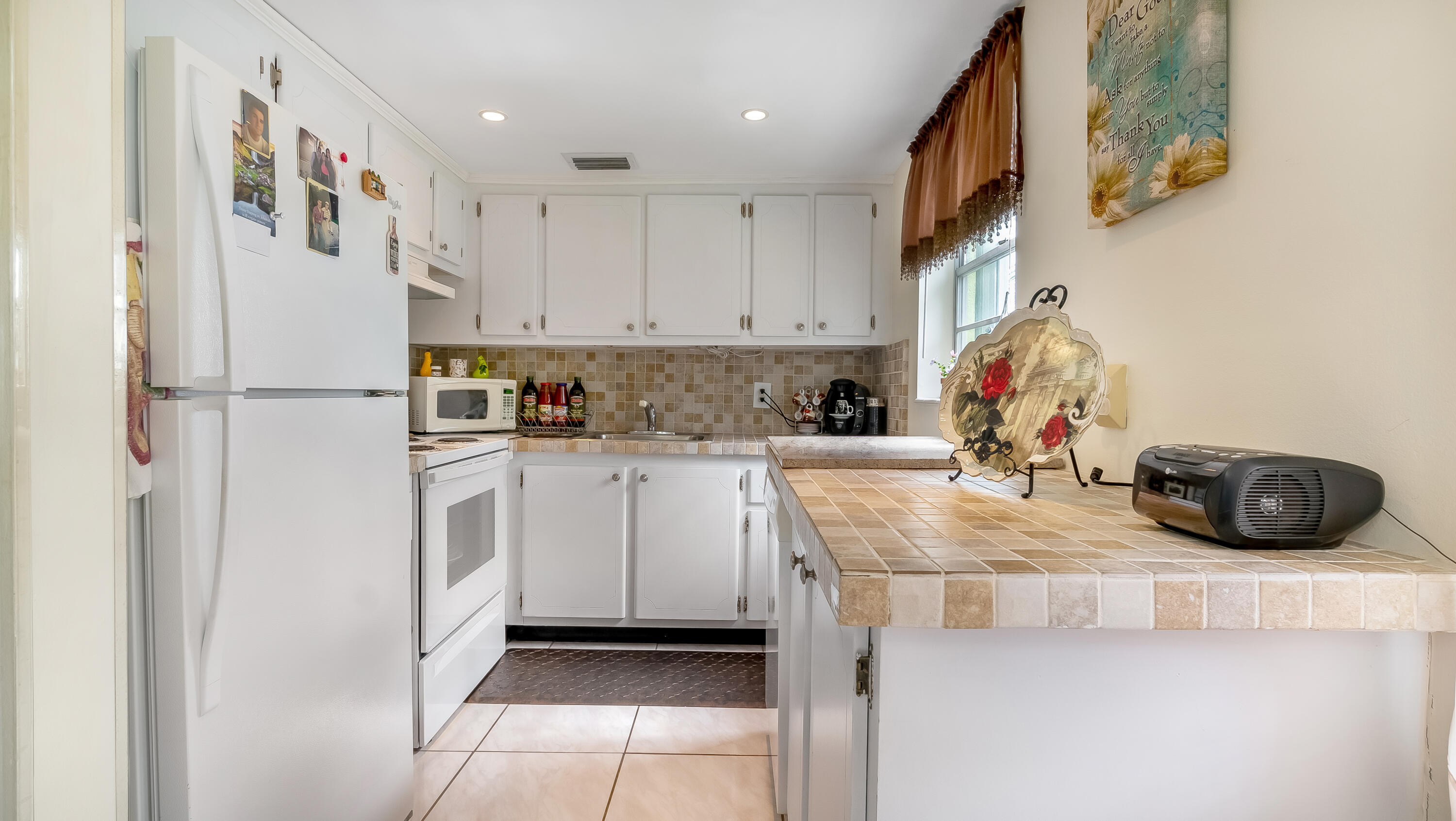 a kitchen with a sink a refrigerator and cabinets