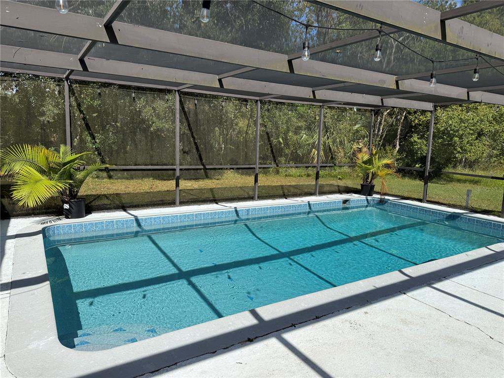 a view of a backyard with a tub and wooden fence