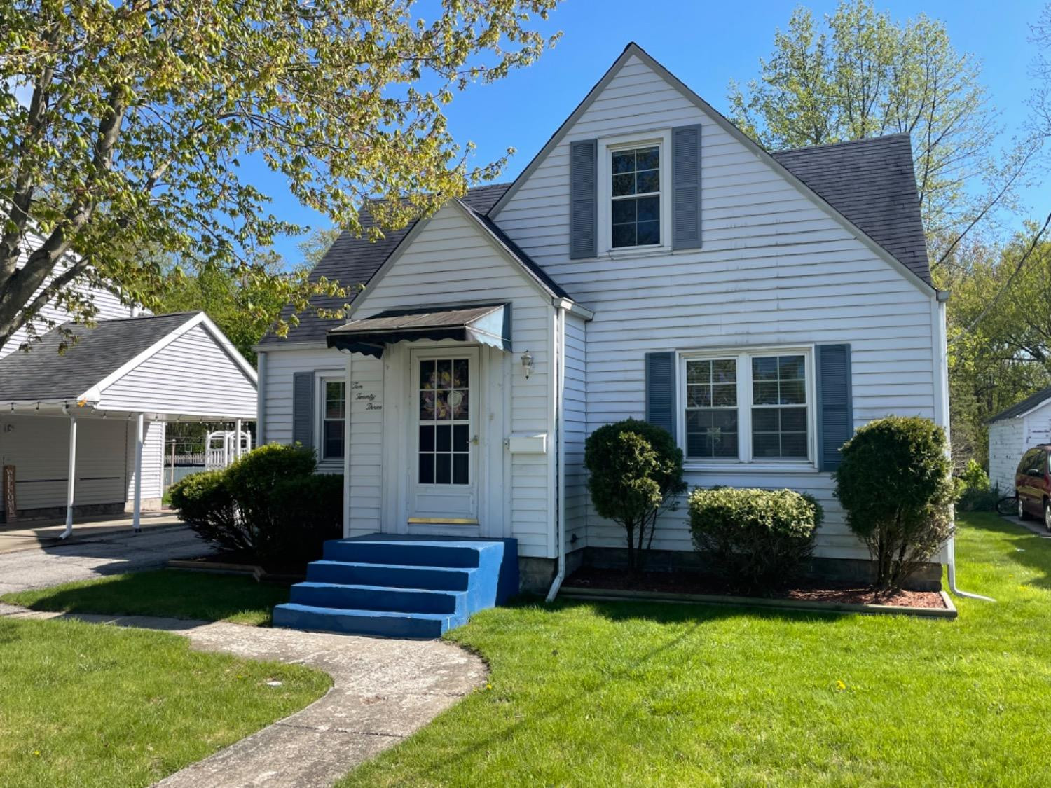 a front view of a house with yard and green space