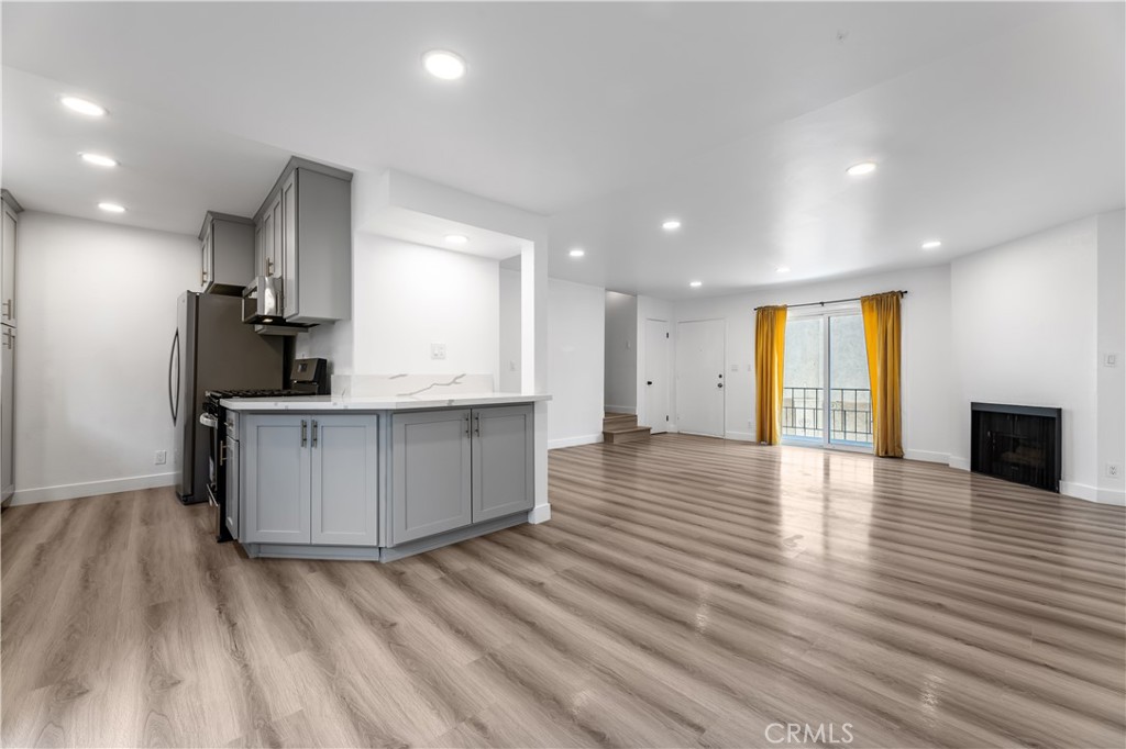 a view of kitchen with wooden floor and electronic appliances