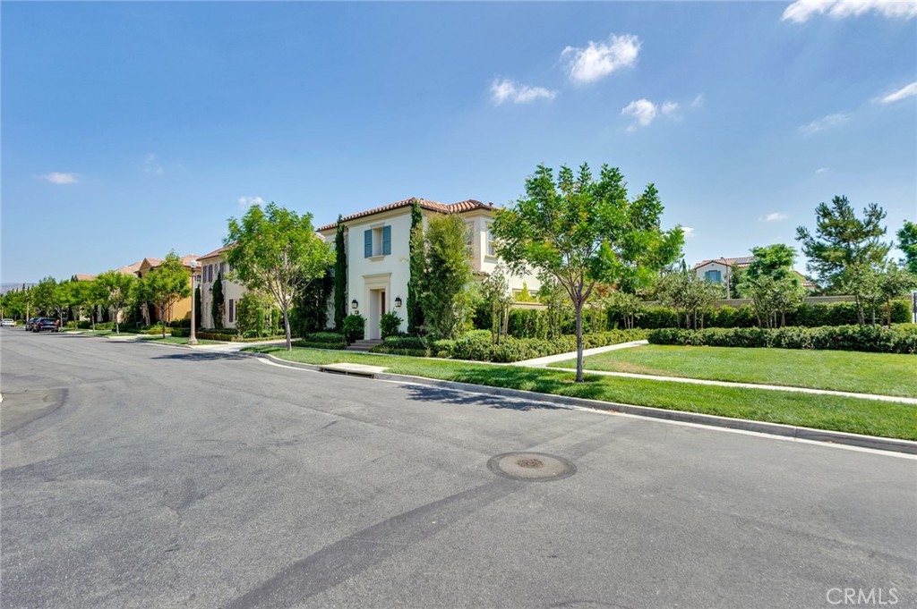 a view of a house with a big yard and palm trees