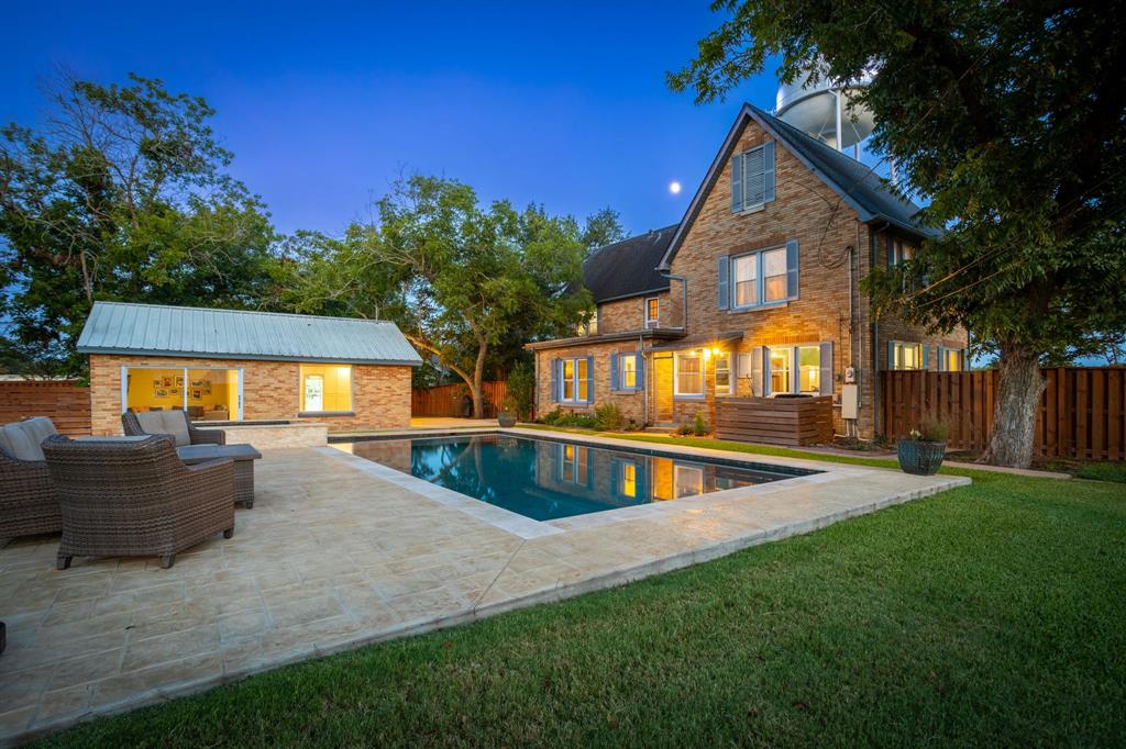 a view of a house with pool and a yard