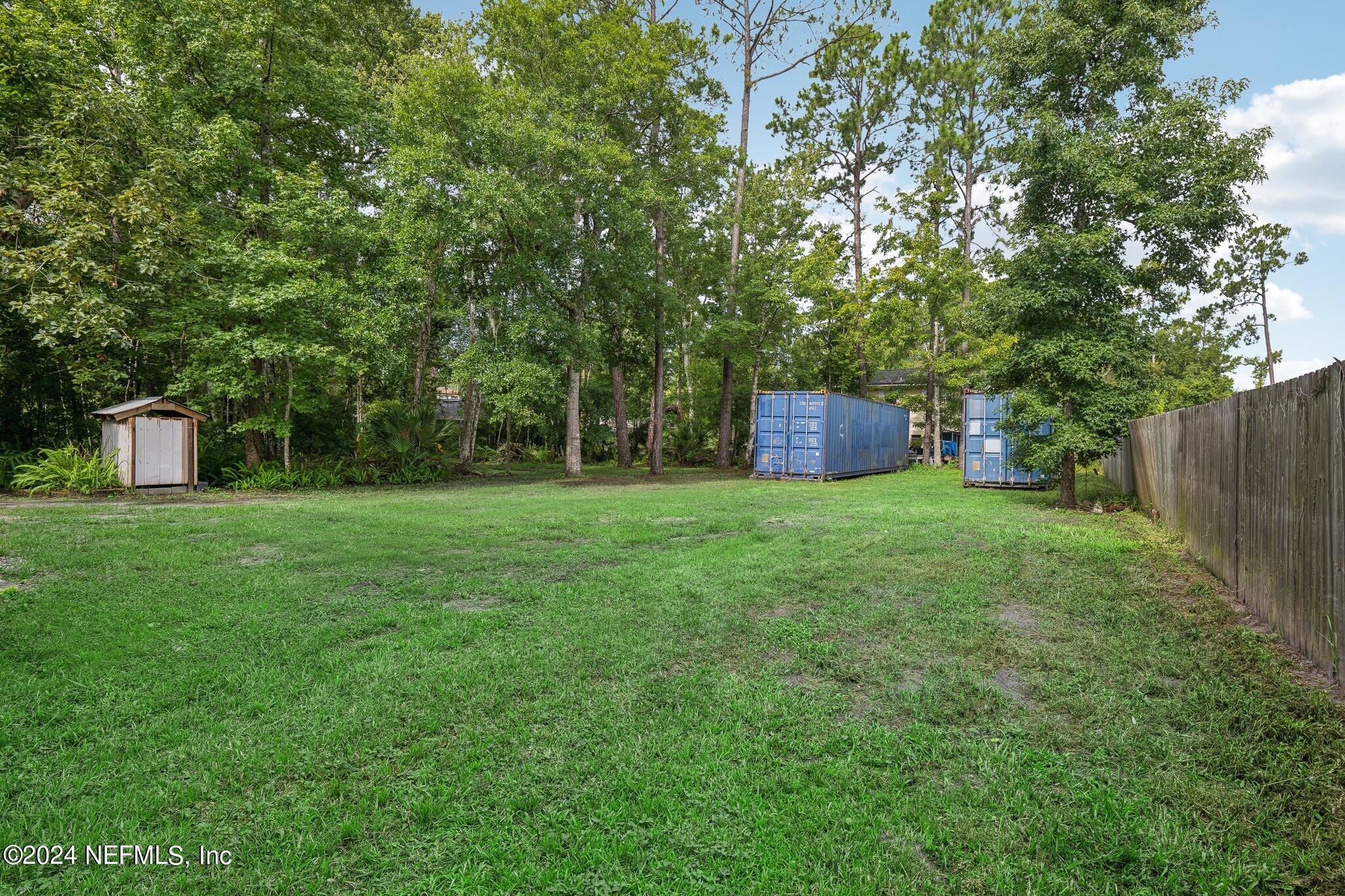 a view of a house with backyard and a tree