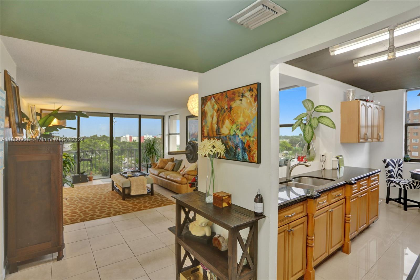 a living room with furniture a flat screen tv and a floor to ceiling window