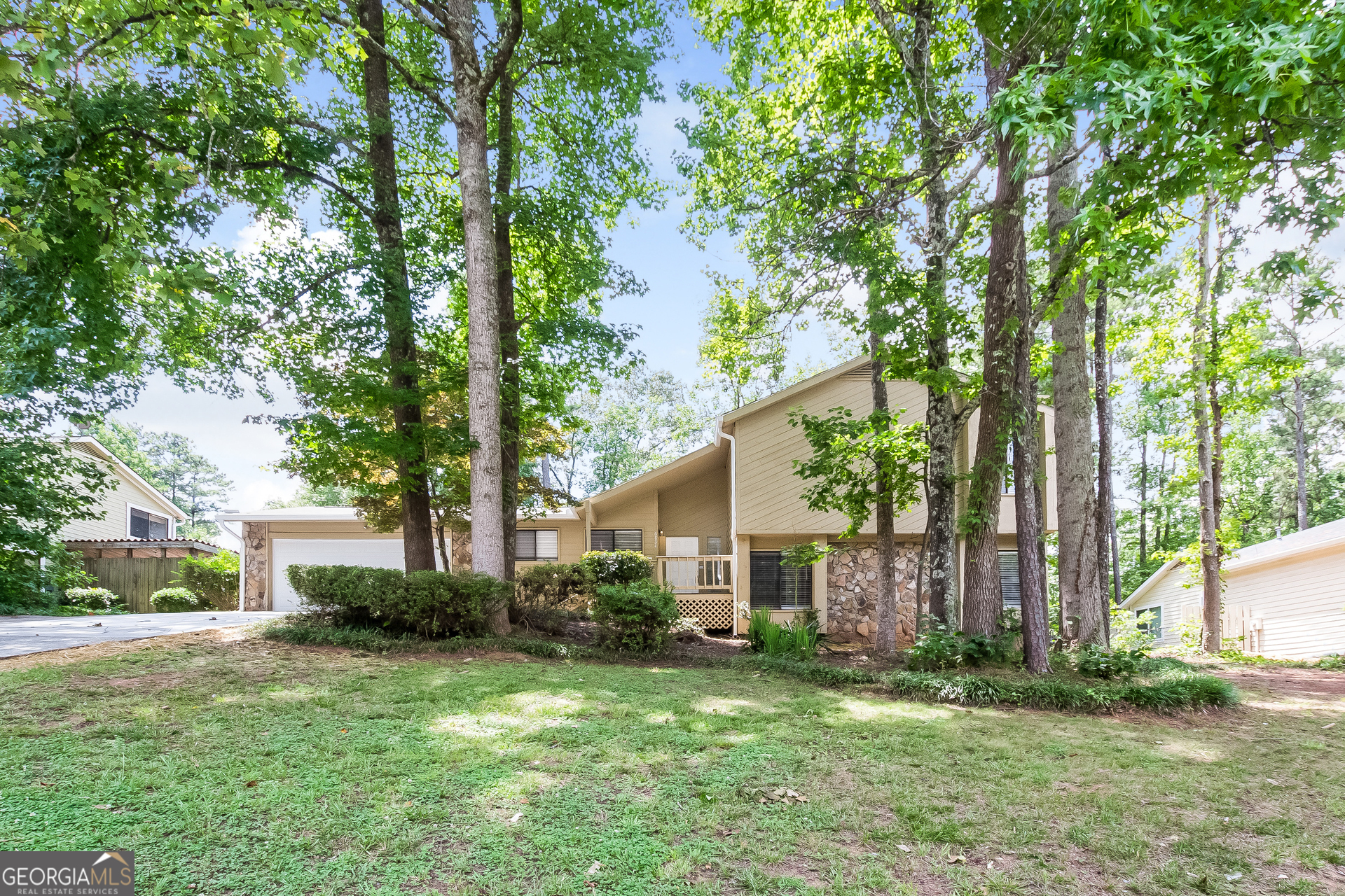 a view of a house with backyard and a tree