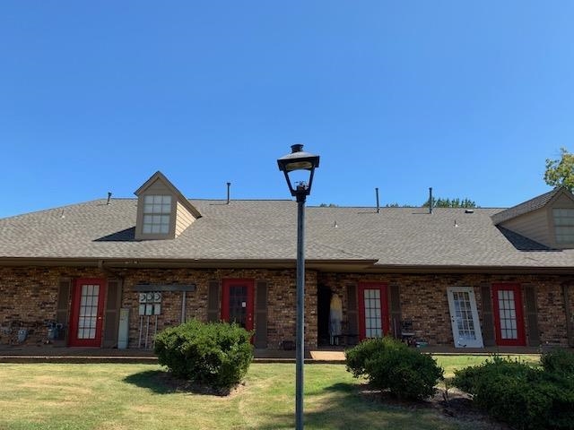 Rear view of property featuring french doors and a lawn