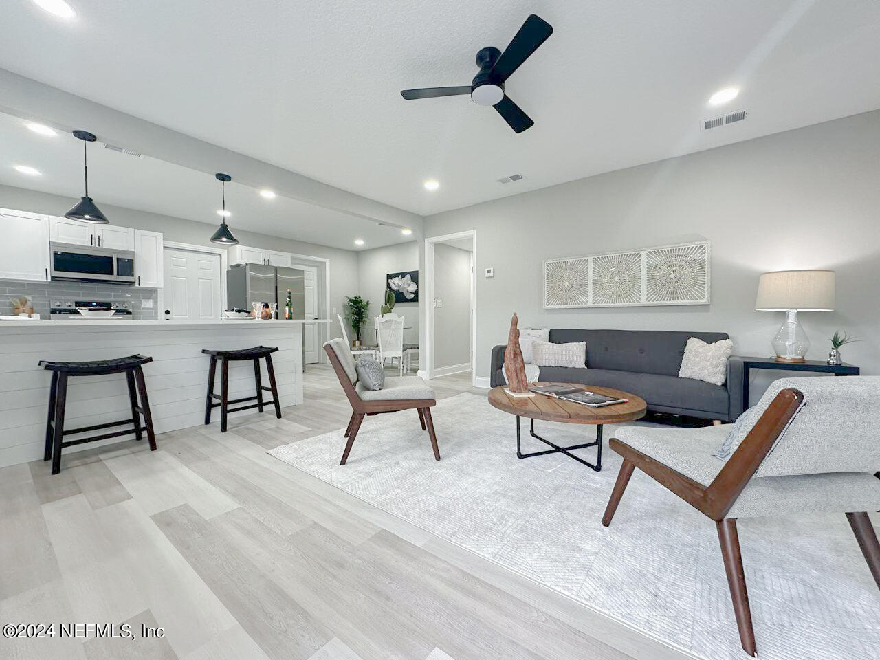 a living room with furniture and a wooden floor