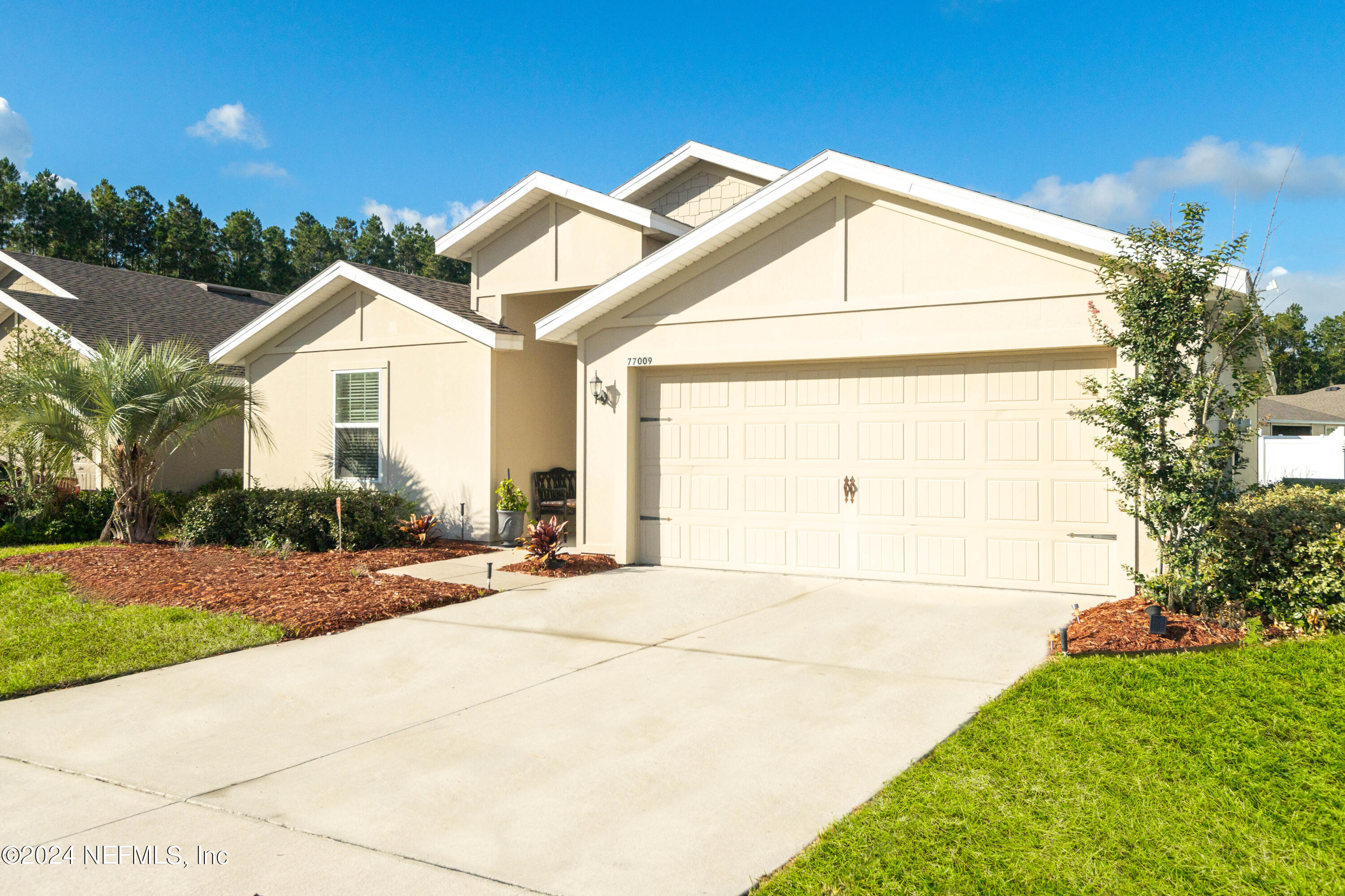 a view of an house with backyard and bushes