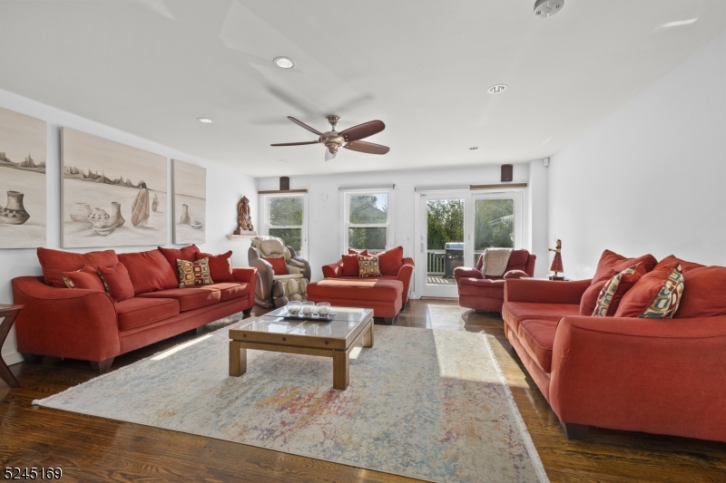 a living room with furniture wooden floor and a large window