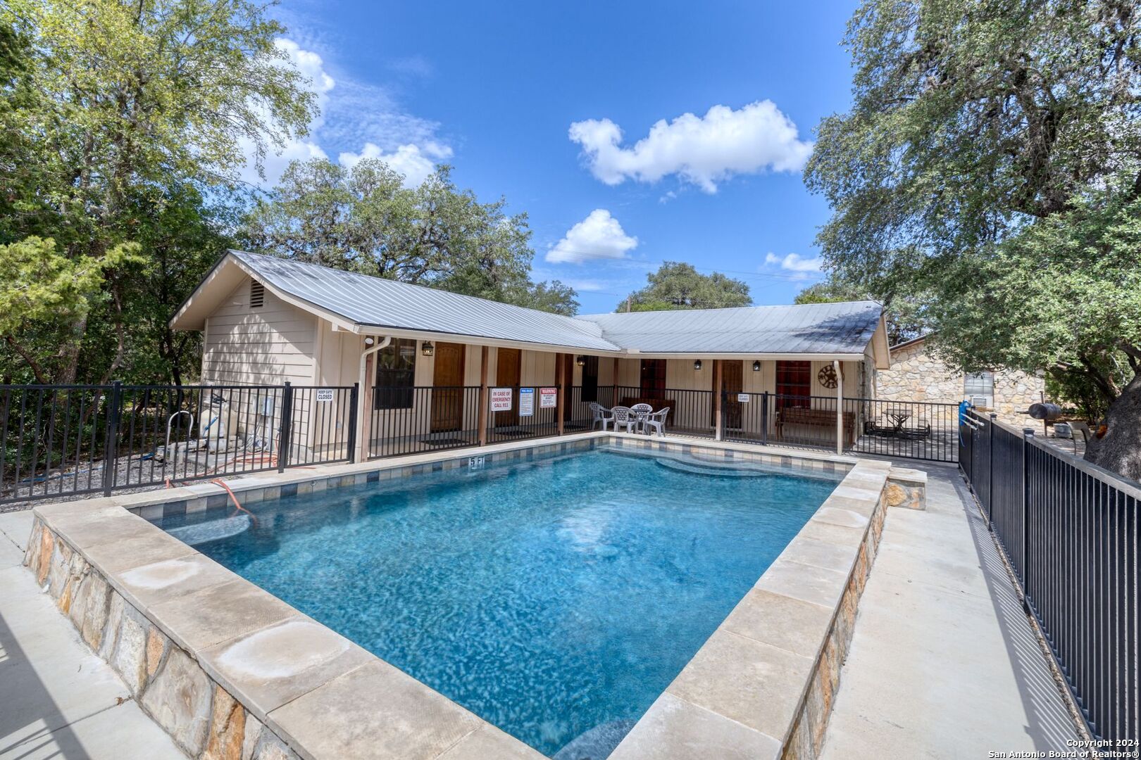 a view of house with swimming pool and sitting area