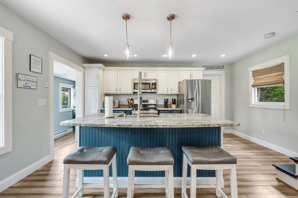 a kitchen with granite countertop kitchen island stainless steel appliances a dining table and chairs