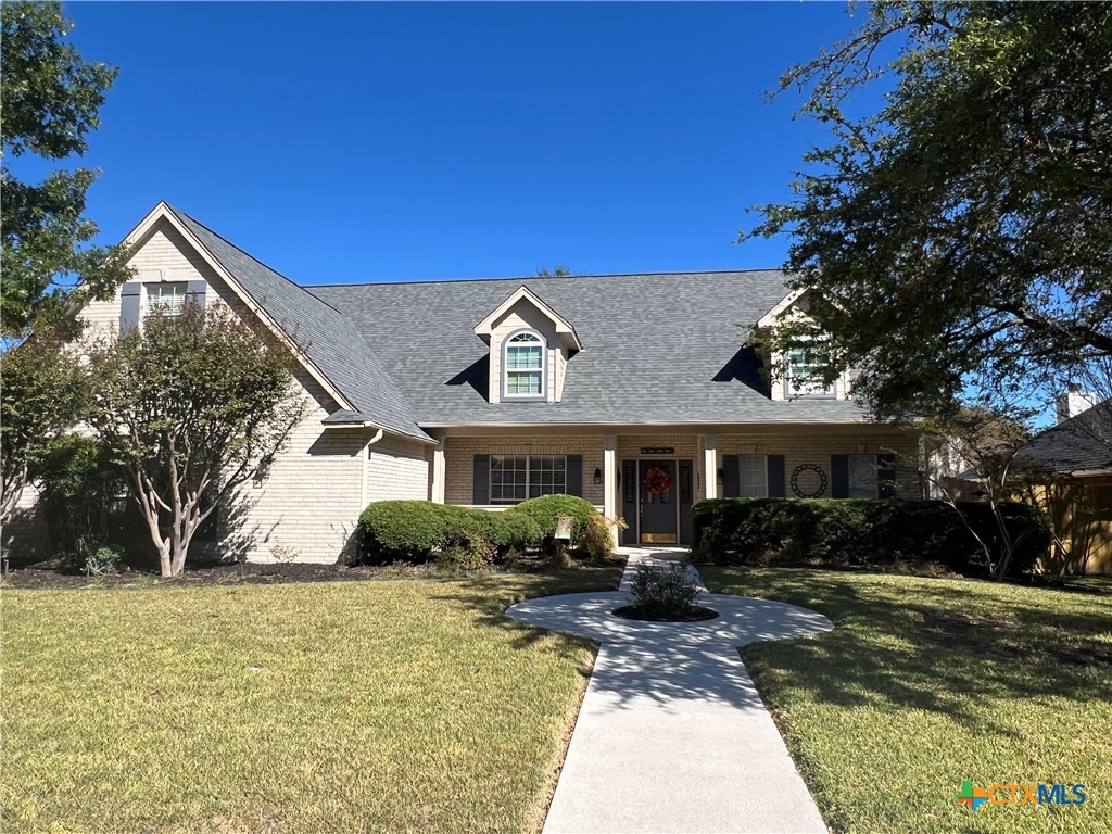 a front view of house with yard and trees around