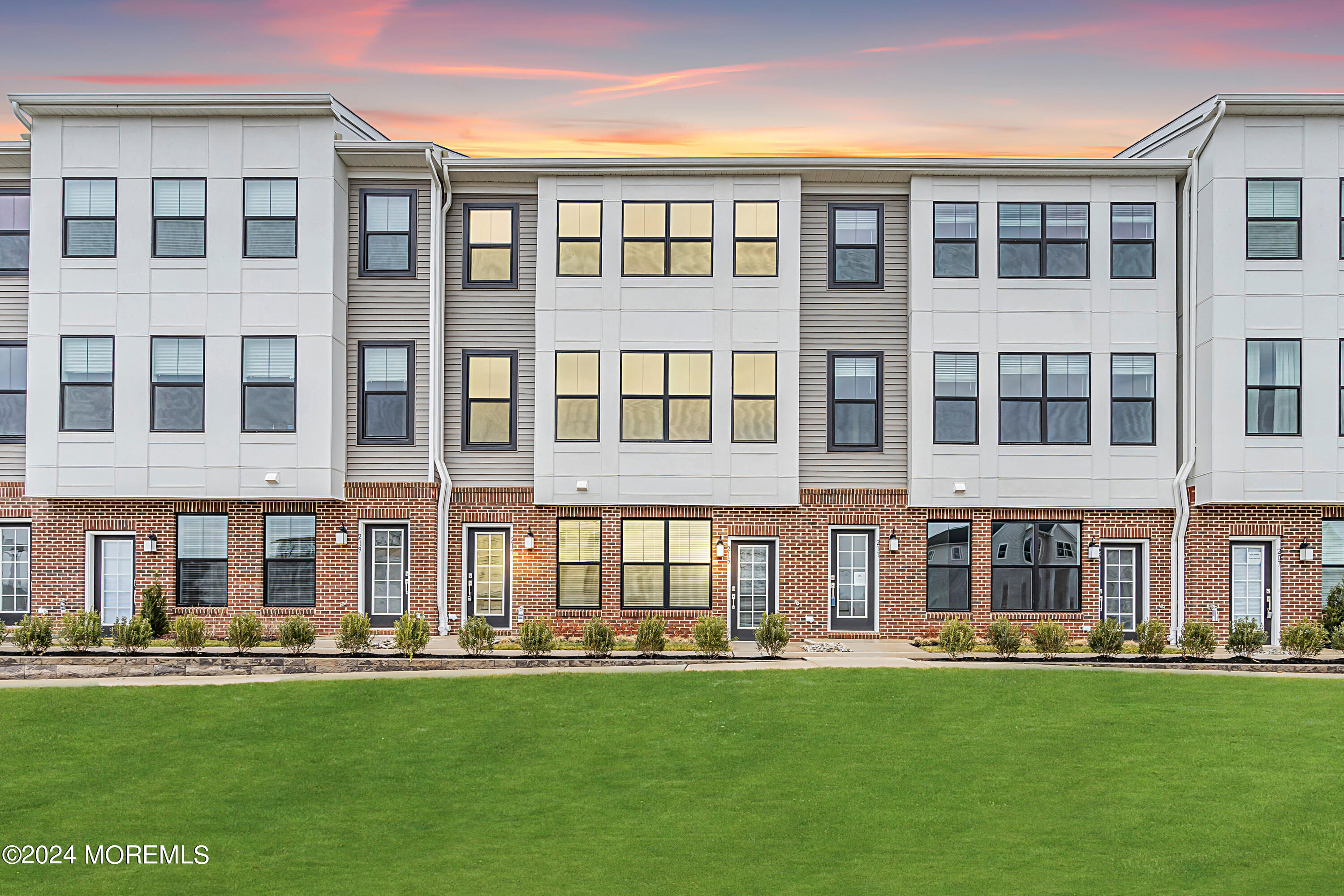 front view of an apartment building with a yard