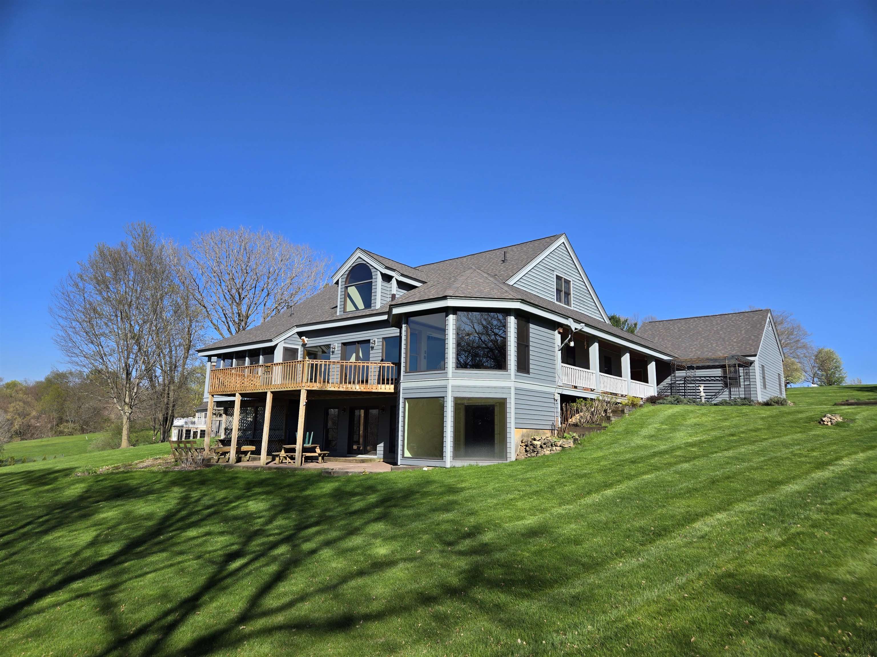 a view of a big house with a big yard and large trees