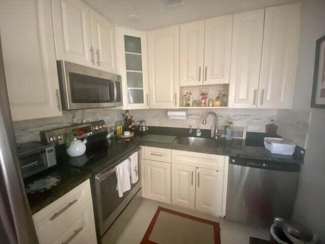 a kitchen with a sink stove top oven and cabinets