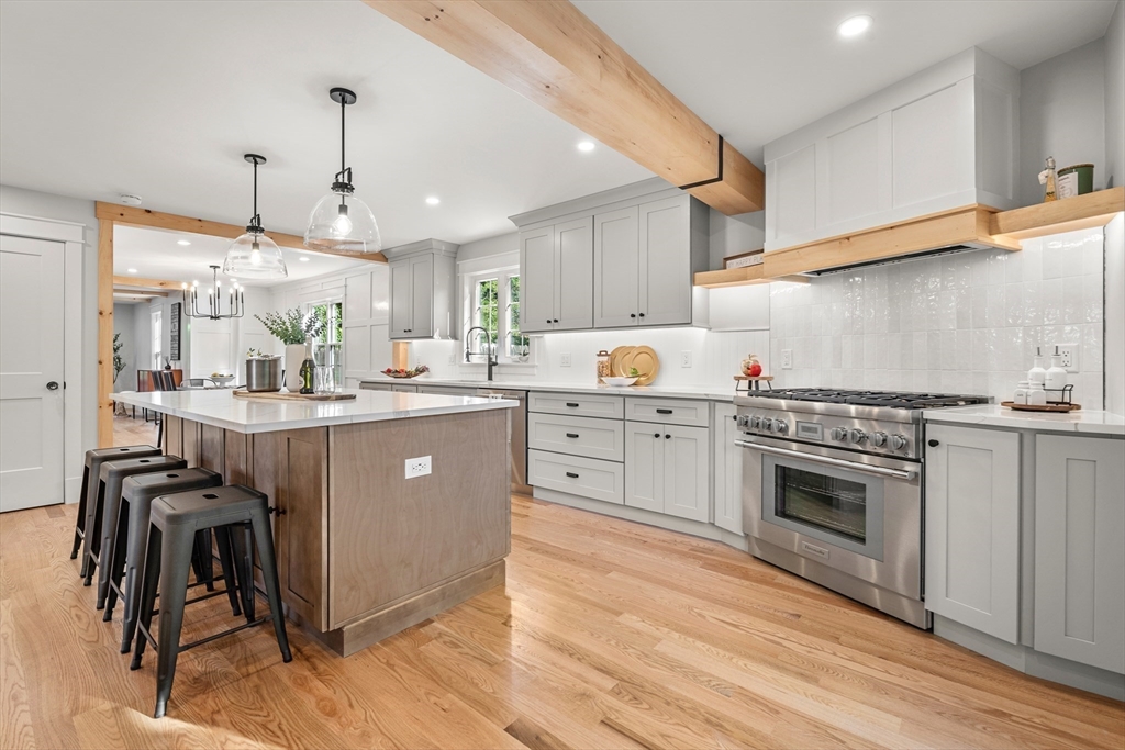 a kitchen with kitchen island a counter top space a sink stainless steel appliances and cabinets