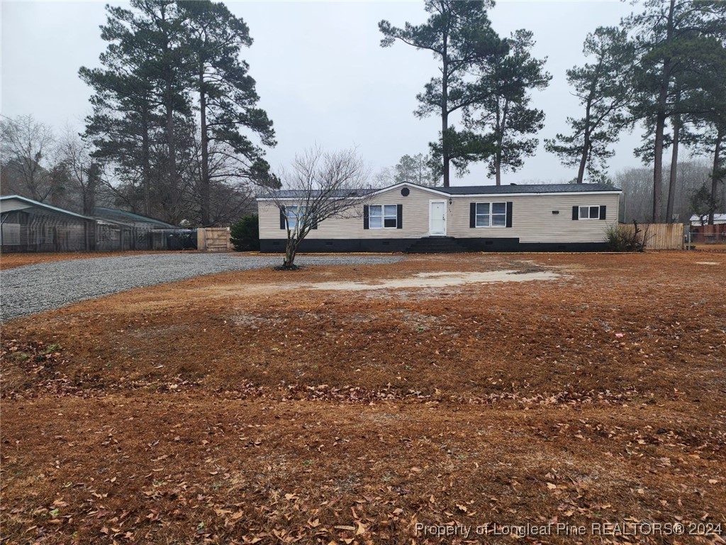 a front view of house with yard and trees in the background