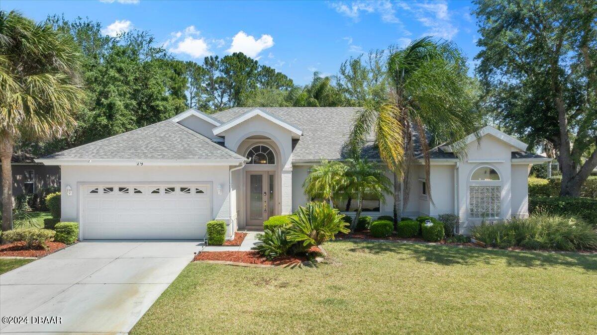 a front view of a house with a yard and garage