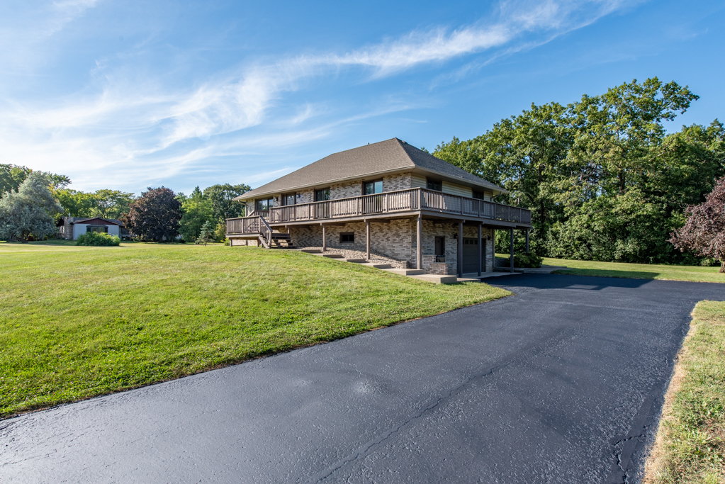 a view of a house with a big yard and large trees