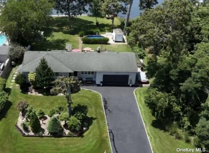 an aerial view of a house with a garden and large trees