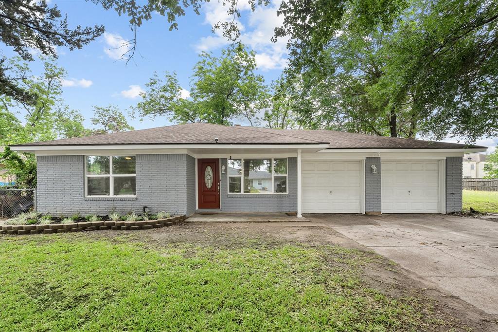 a front view of house with yard and trees in the background