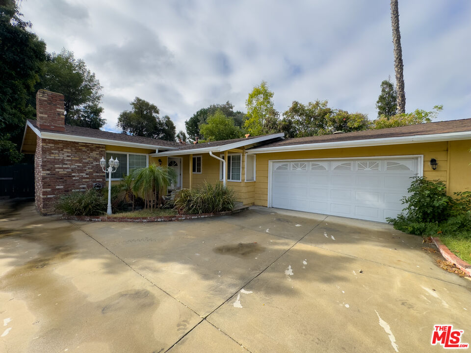 a view of a house with a backyard and basketball court