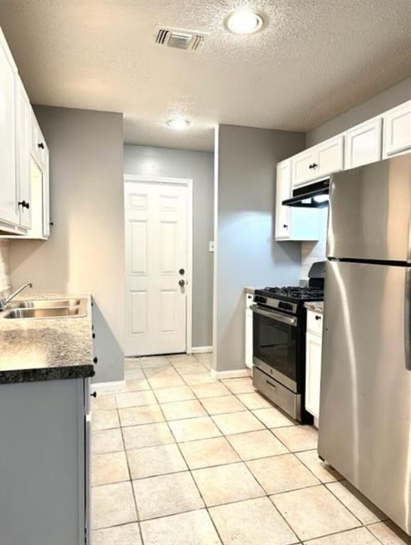 a kitchen with granite countertop a refrigerator and a sink