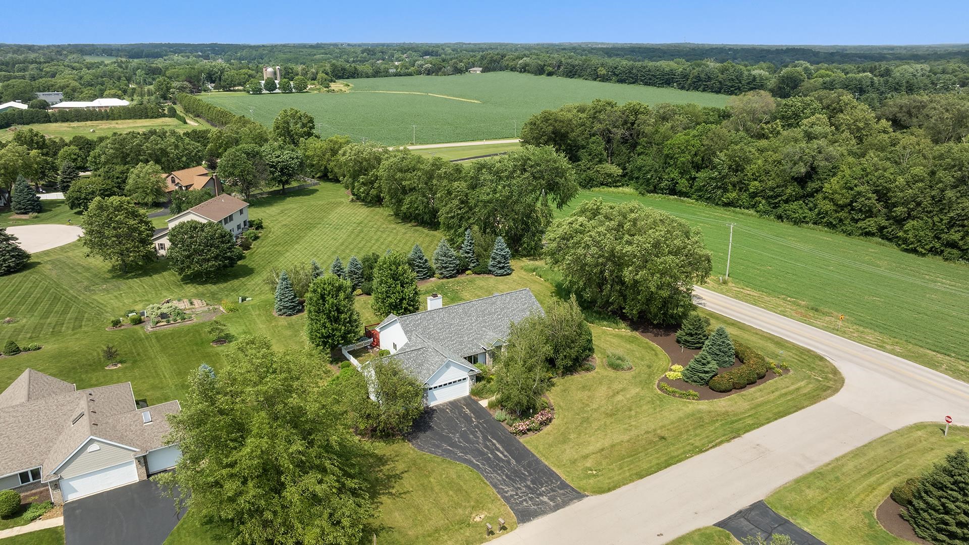 an aerial view of green landscape with trees houses and lake view