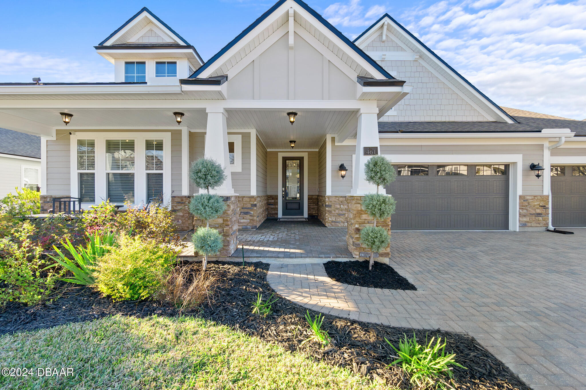 a front view of a house with a yard and outdoor seating