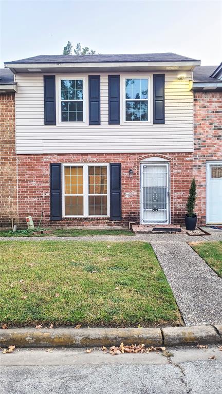 front view of a brick house with a yard