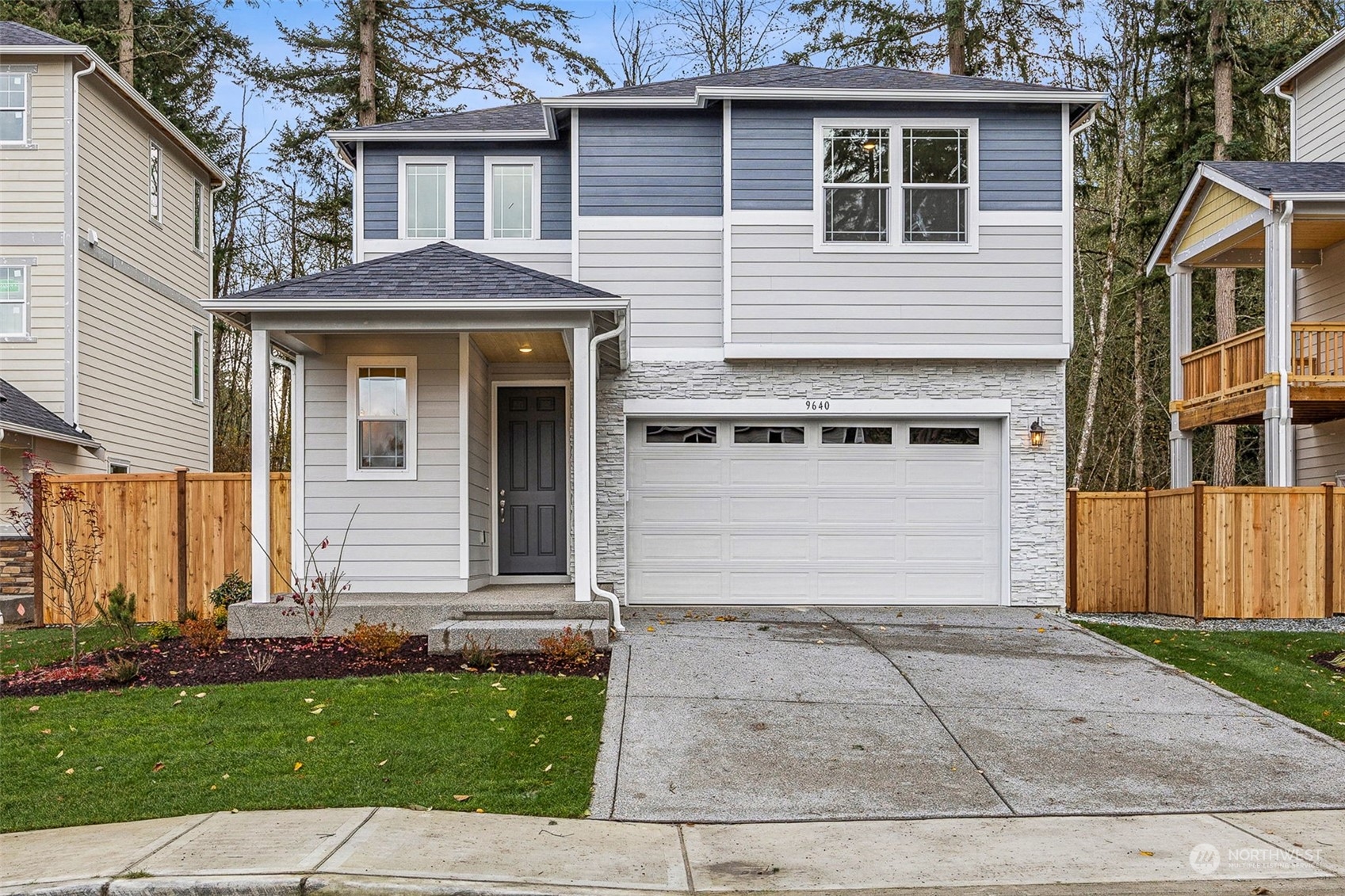 a front view of a house with a garden and garage