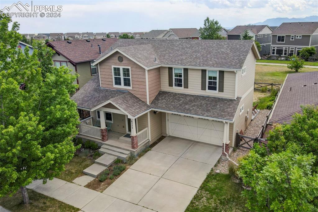 a aerial view of a house with a yard and potted plants