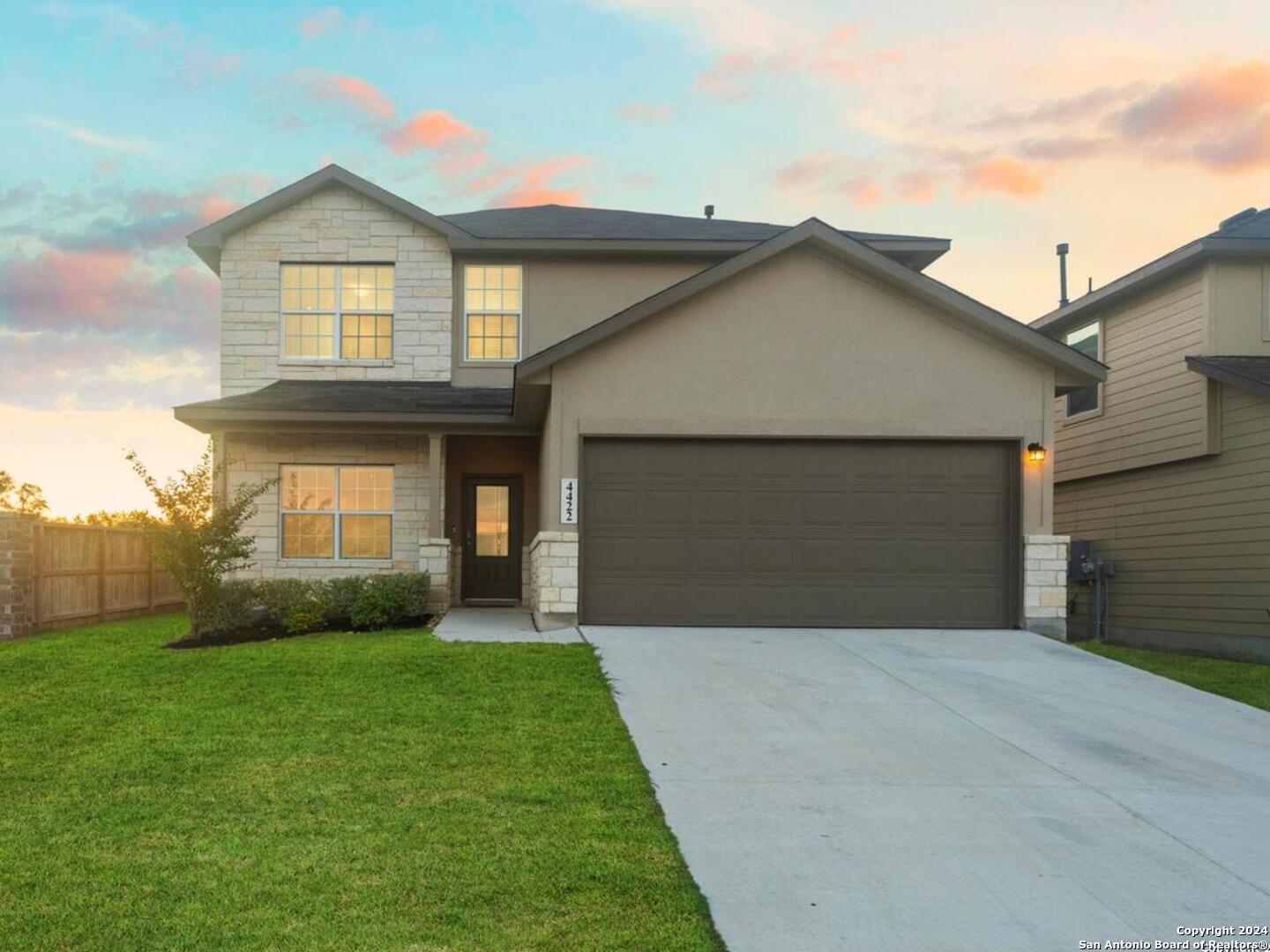 a front view of a house with a yard and garage