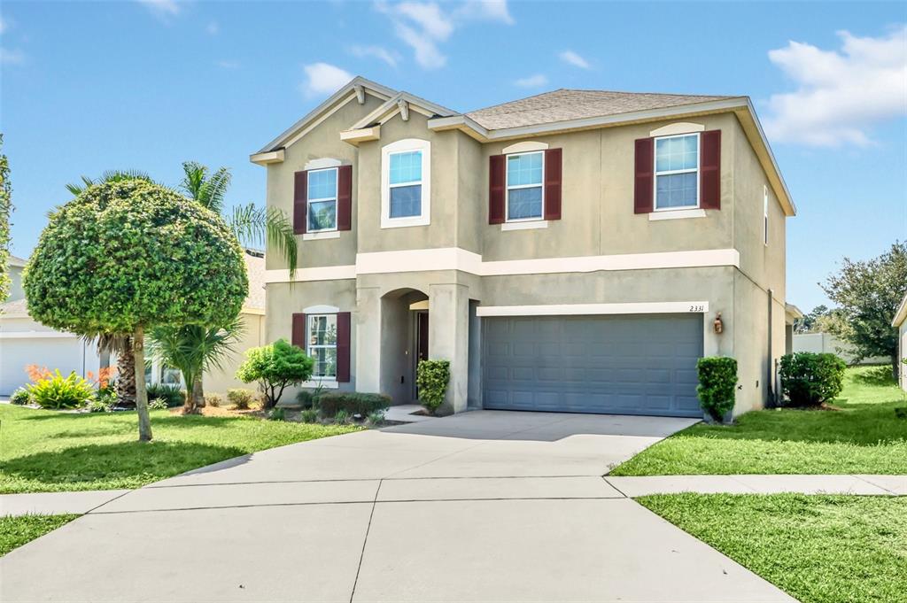 a front view of a house with a yard and garage