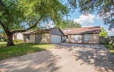 a view of a house with a yard and large trees