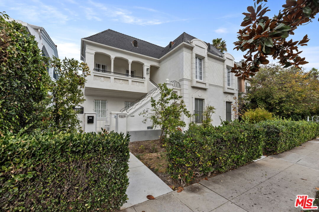 a front view of a house with plants